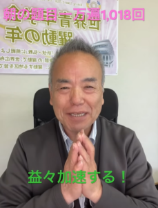 Smiling man seated in an office chair, hands pressed together in a prayer-like gesture; pink and green Japanese caption overlays above and below.
