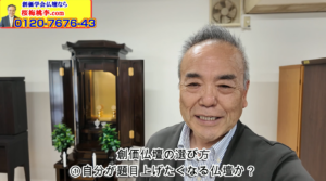 笑顔の中年男性が仏壇の前で自撮りしている。背景に木製の仏壇と飾り、左上には黄色の広告バナーと電話番号「0120-7676-43」が見える。