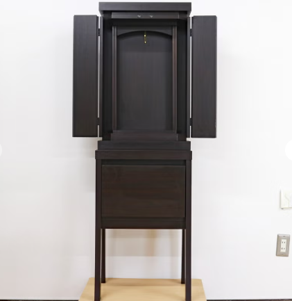 Dark wooden home altar cabinet on a tall stand with its doors open, revealing an inner shrine space.