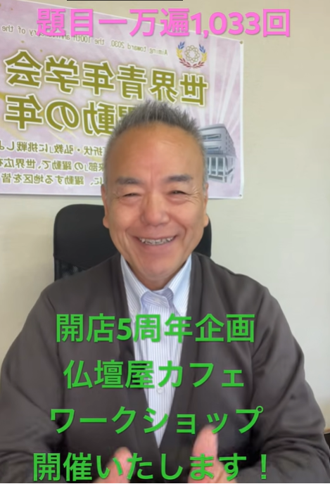 Smiling man seated in front of a poster announcing a five-year shop anniversary and a Buddhist altar shop cafe workshop. The green Japanese text is part of the promo.