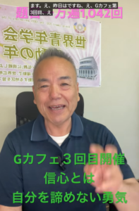 Smiling man speaks to camera in an office; behind him is a poster and green Japanese text announcing 'Gカフェ3回目開催' for a session.