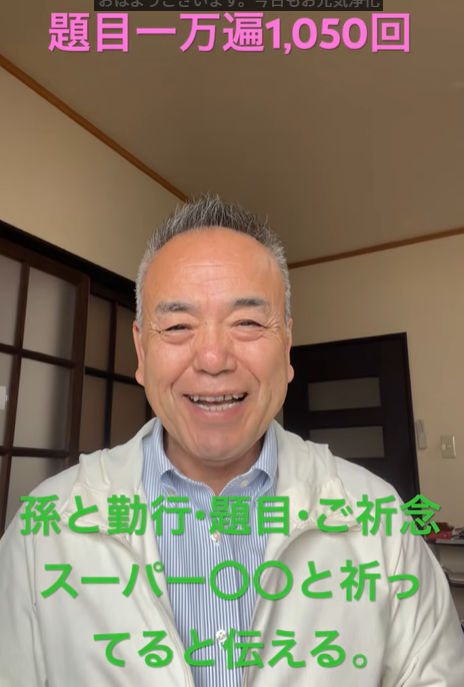 Smiling Japanese man in a light jacket speaks in a home setting; pink title text above and green caption about prayers overlay the image.