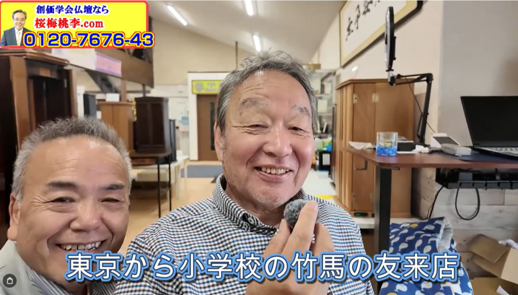 Two smiling men pose together in a cluttered shop, with furniture and a laptop visible in the background, as a bright ad banner sits in the top-left corner.
