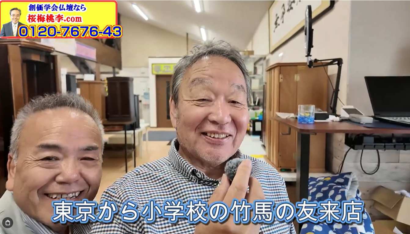 Two smiling men pose together in a cluttered shop, with furniture and a laptop visible in the background, as a bright ad banner sits in the top-left corner.