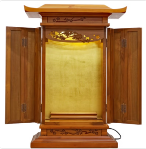 Open wooden butsudan-style home altar with gold interior and carved floral details.