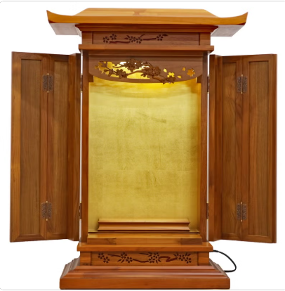 Open wooden butsudan-style home altar with gold interior and carved floral details.