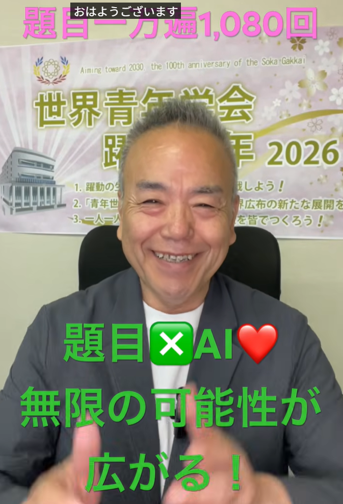 Smiling man in a gray blazer sits in front of a banner about an AI event, with large Japanese text on screen.