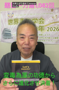 Smiling man seated, holding a book titled 'Let's Daimoku!' in front of a large Japanese event banner and a neon green subtitle across the bottom.