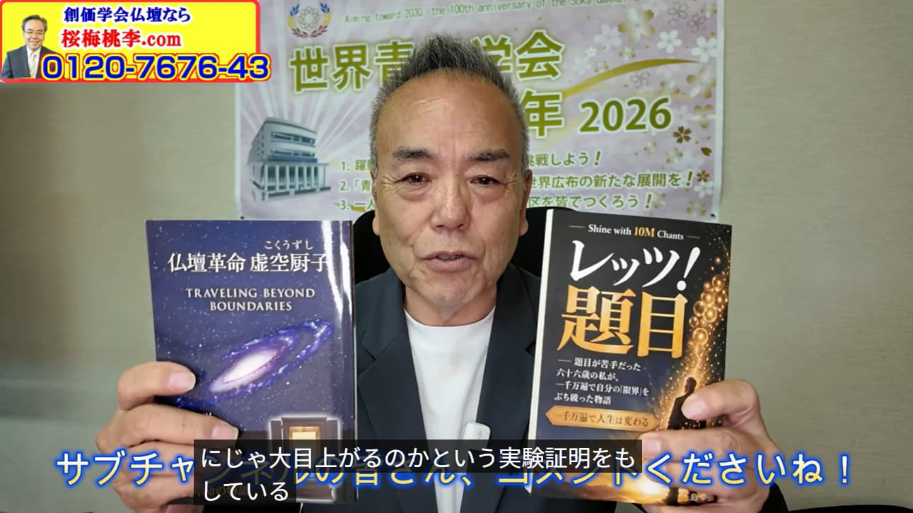 Man in a suit holds up two books for the camera, one about 'Traveling Beyond Boundaries' and a Japanese title on the other, with a banner in the background and a yellow ad in the corner.