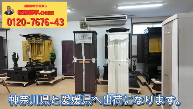 Indoor showroom displaying several coffins and funeral display pieces; a yellow promotional banner with a phone number (0120-7676-43) is in the top-left, and blue Japanese caption at the bottom mentions shipping to Kanagawa and Ehime.