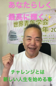 Smiling man in a white shirt gives a thumbs-up, with pink and green motivational Japanese text overlaid and a poster in the background promoting a youth group event.