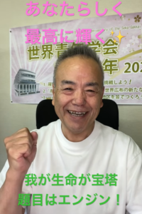 Smiling man in a white shirt raises a clenched fist, with a banner containing pink text overhead and green text at the bottom in the background.