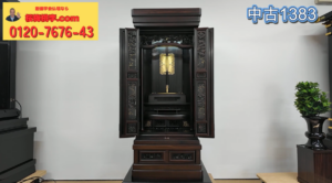 Open antique wooden Buddhist altar (butsudan) with ornate carvings and a gold center, on a multi‑tier pedestal; yellow ad banner with red text and phone number in the upper left and blue '中古1383' in the upper right.