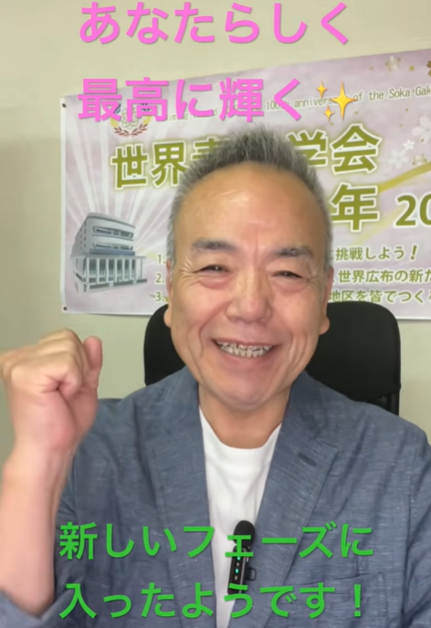 Smiling man in a blue blazer raises his fist in a video thumbnail, with a poster and bold pink and green captions behind him.