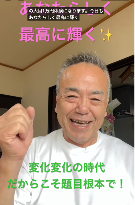 Smiling older man in a white shirt raises his fist in a home interior, with pink and green Japanese captions about staying positive and embracing change overlaid.