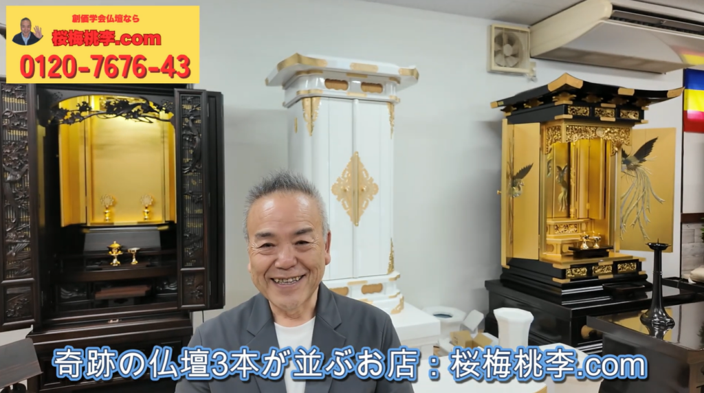 Smiling man in a gray jacket standing in a showroom, flanked by ornate gold and white Buddhist altars; blue caption text runs along the bottom in Japanese.