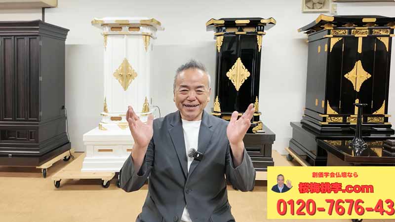 Smiling man in a gray suit sits with hands raised in a showroom, ornate black and white coffins on display behind him, plus a yellow ad banner in the corner.