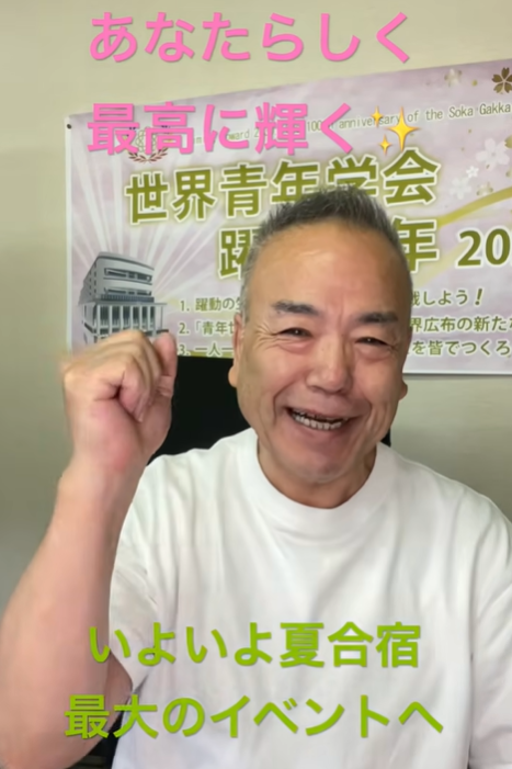 Smiling man in a white shirt raises a fist in celebration, with pink text above and green text below announcing a summer camp event in Japanese.