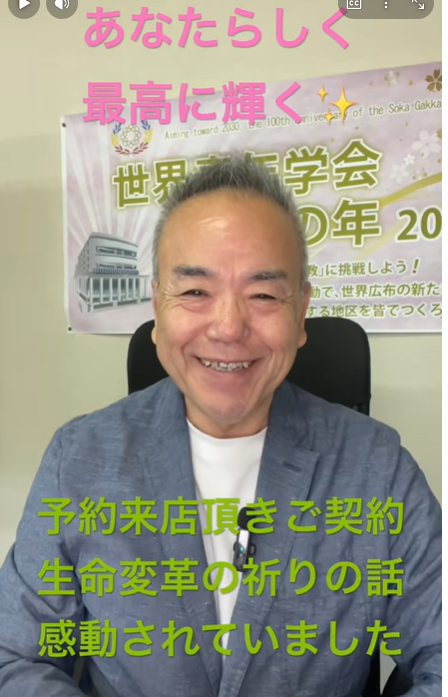 Smiling man in a blue blazer sits in front of a banner with pink text 'あなたらしく 最高に輝く' and green captions about a life-changing talk.